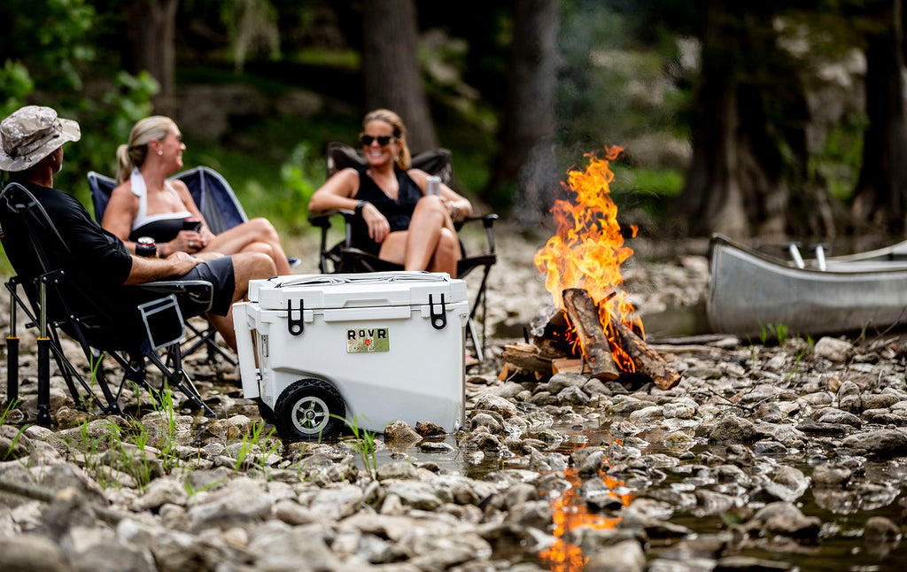 Powder cooler pictured in front of group of friends seated around a fire.